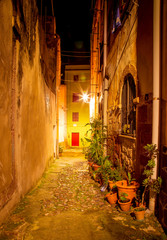 Fototapeta na wymiar Narrow ancient streets during the evening in the little medieval town Bosa, Sardinia Island, Italy