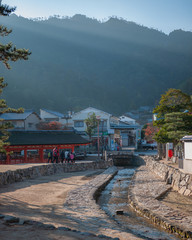 Photo of a river stream leading up to the hills, which goes past the exit of Itsukushima Shrine (to...