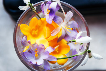 Spring bouquet of different flowers in a glass.