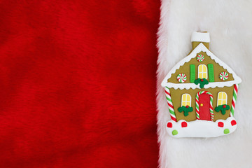 Christmas gingerbread house on red and white plush textured fabric background