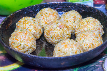 Sculpt meat meatballs with rice, carrots and herbs.