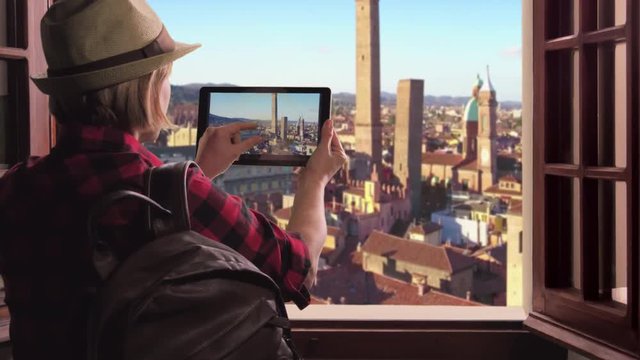 tourist takes photo bologna towers,traveler woman photographs bologna city using tablet high view