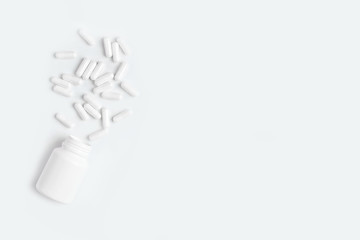 White pills spill out of the bottle.