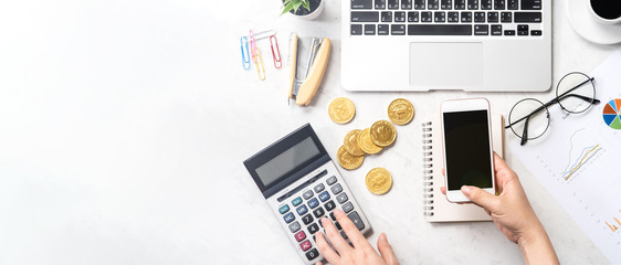 A woman is calculating the fee, profit and doing a payment online on a modern marble office table, mock up, top view, copy space, flat lay, lifestyle - obrazy, fototapety, plakaty