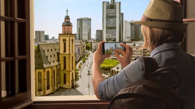 tourist taking picture of frankfurt cathedral,woman takes photo of city center using smartphone high view