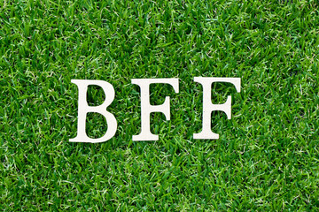 Wood letter block in word BFF (Abbreviation of best friend forever) on artificial green grass background