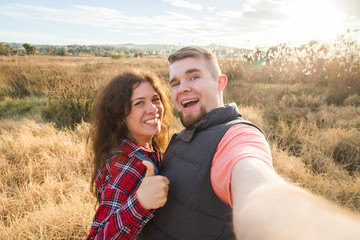 Travel, vacation, summer and holiday concept - Happy couple taking selfie outdoors