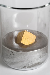 Brass block floats on liquid mercury.