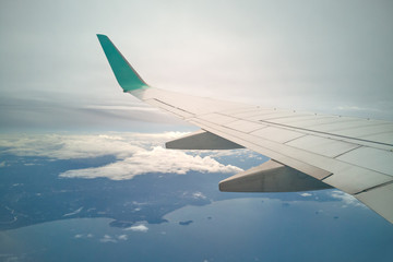 Obraz premium wing of airplane and sky landscape. the earth and the blue sea background