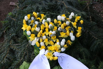 Herz aus Blumen auf dem Friedhof im Frühling