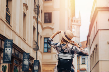 Tourist girl walking along streets of Europa old houses, sunlight. Concept travel lifestyle