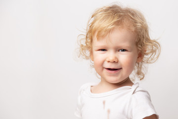 Naklejka premium portrait of cute caucasian smiling curly baby girl in dirty white clothes t-shirt on white background.