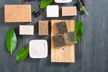 cosmetic clay, soaps, henna blocks, raw shea butter on black wood table