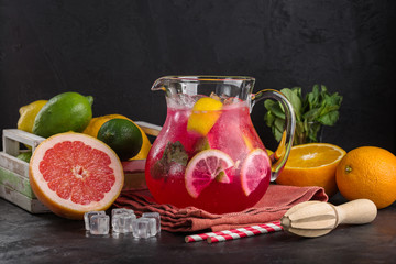red lemonade in a jug, a refreshing drink, citrus fruits, a dark background, a restaurant menu, a copy place