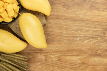 Fresh mango top view. wooden background and copy space for add text.