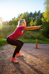 Photo of young girl stretching in summer park