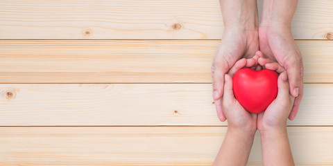 I love you Mom, Mother's Day celebration with woman parent holds young kid's hands supporting red heart gift, csr charity donation, parenting or children adoption family health nursing care concept