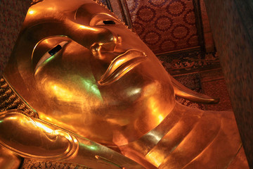 Reclining Buddha gold statue face in Wat Pho, Bangkok