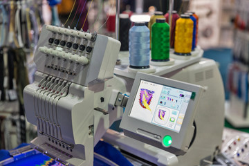 professional machine for applying embroidery with colorful reels of threads