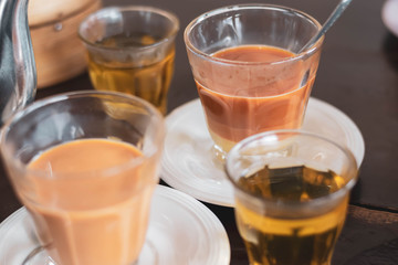 Thai tradition hot tea with sweetened condensed milk in old style cup (Selective focus)