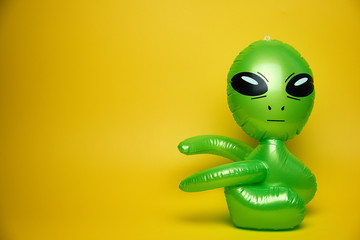 green alien looks,yellow background