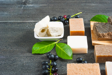 cosmetic clay, soaps, henna blocks, raw shea butter on black wood table