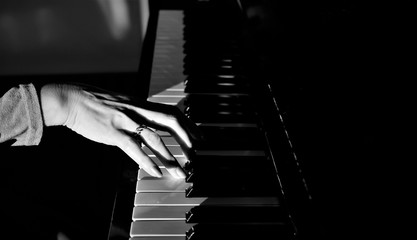 Obraz na płótnie Canvas 朝陽を浴びるピアノを弾く女性の手