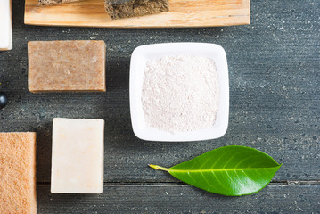 cosmetic clay, soaps, henna blocks, raw shea butter on black wood table