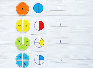 Colorful bright fractions in mathematics on white wooden table. interesting math for kids children. Education, back to school concept