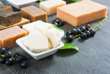 cosmetic clay, soaps, henna blocks, raw shea butter on black wood table