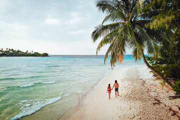 Couple homme femme qui marche sur la plage avec palmiers