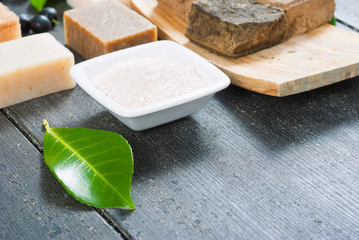 cosmetic clay, soaps, henna blocks, raw shea butter on black wood table