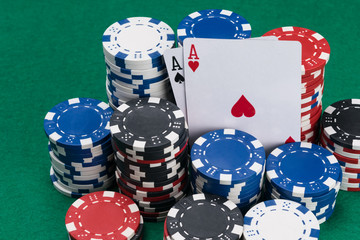lots of poker chips and two winning cards on the green table
