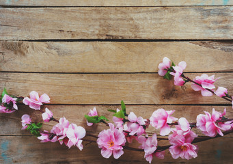 Cherry blossom and Artificial flowers on vintage wooden background with copy space.