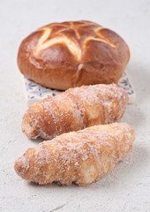 sugary croissants and sweet bun on white textured background