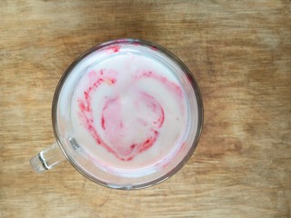 Top view on a glass of yogurt mixed with honey and raspberries mash