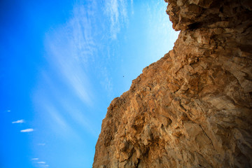 Steep rock A bird is flying against the blue sky