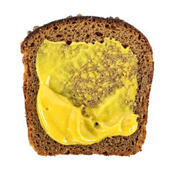 Slice of rye bread and mustard on a white background, top view.