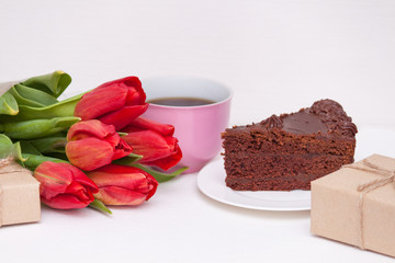 Tulips, presents, cake, cup for mother, wife, daughter, girl with love. Happy birthday, Mother's day. Woman's day.