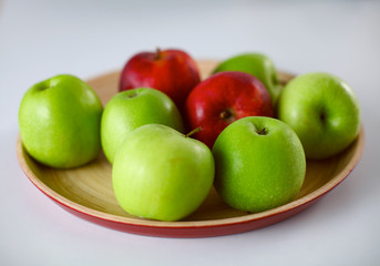 wooden plate with ripe fresh red and green apples
