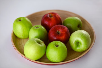 wooden plate with ripe fresh red and green apples