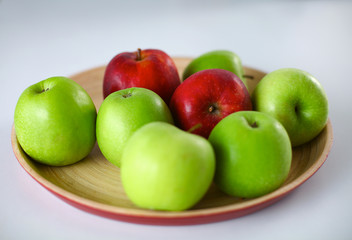 wooden plate with ripe fresh red and green apples