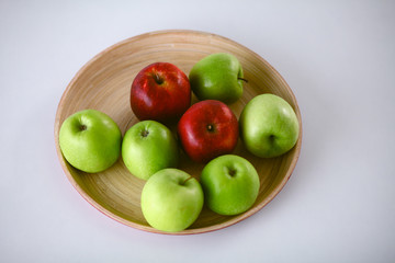 wooden plate with ripe fresh red and green apples