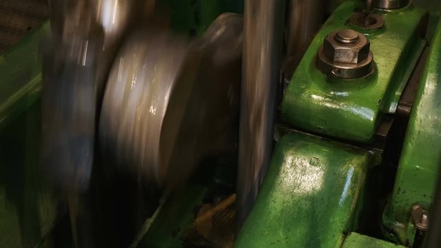 Close-up shot of a flywheel of a single cylinder industrial steam engine in operation