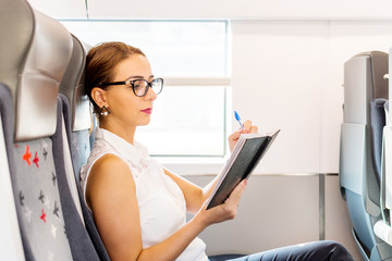 business woman reading diary on the train