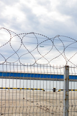 Fototapeta premium Barbed wire at the marina sea daytime