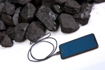 A smartphone connected directly to the hard coal prism to recharge the batteries. Ecological use of...
