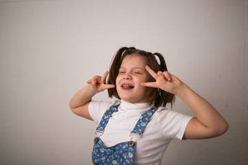 Fototapeta premium kid girl with funny tails and grimace, Fool's day