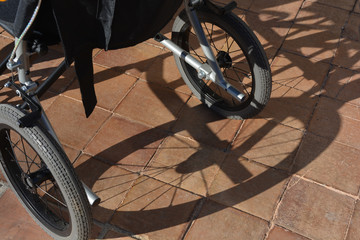 Fototapeta na wymiar wheelchair, shadow of wheel on terracotta tiles