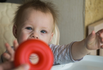 happy toddler baby boy sorting colorful rings on pyramid